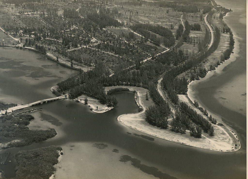 A black-and-white aerial photo of a land development by the water.