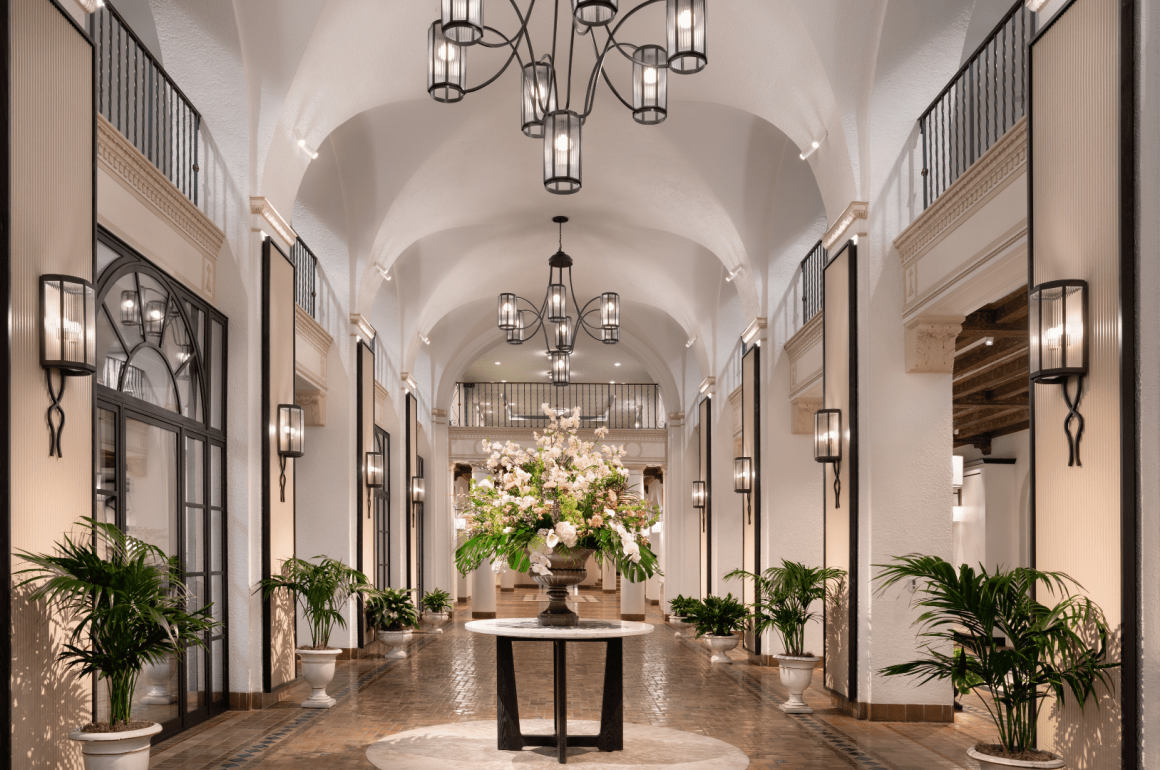 A photo of a gleaming white hotel lobby with black fixtures and accents.